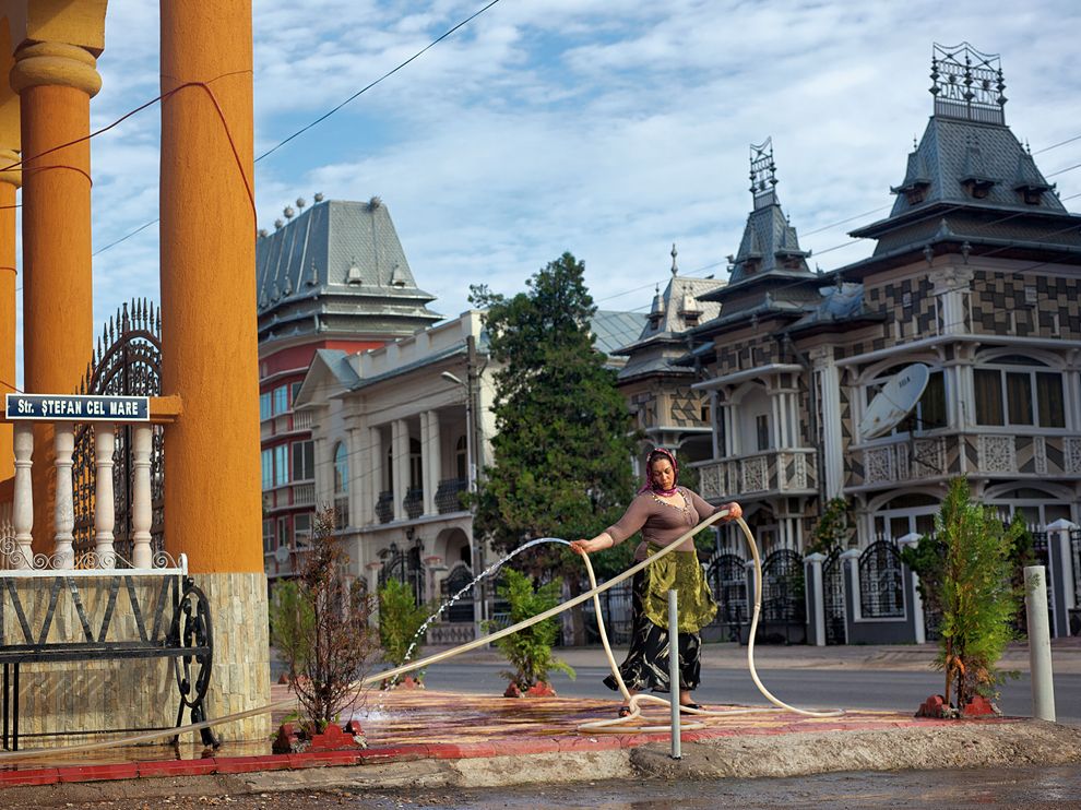 Picture of a woman cleaning in front of a house in Romania  